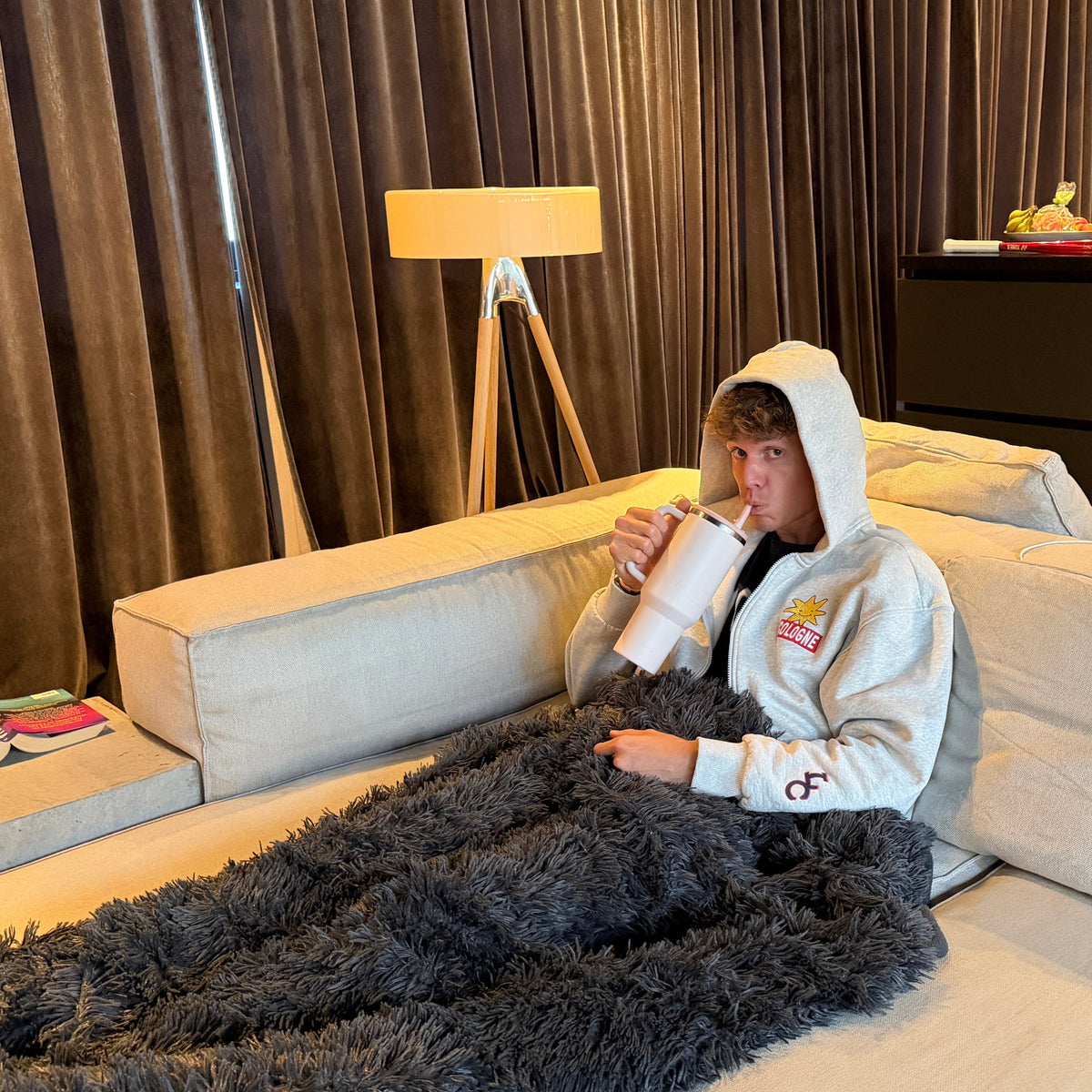 Graue LUCREW Patches Hoodie Jacke von LaserLuca auf dem Sofa